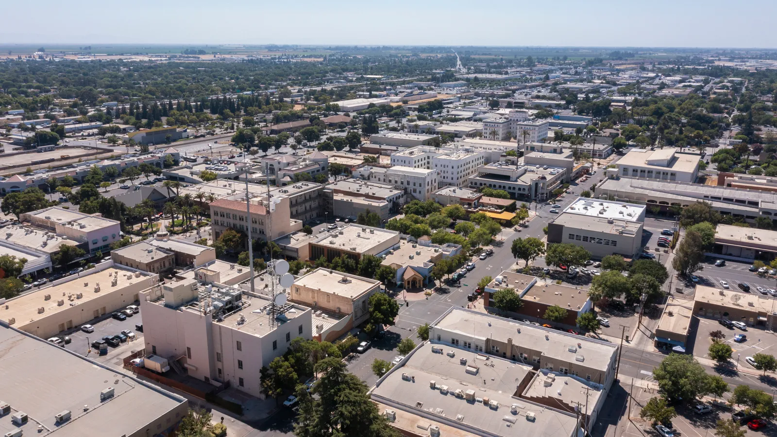 Aerial view over downtown Merced toward the flat Central Valley farmland beyond